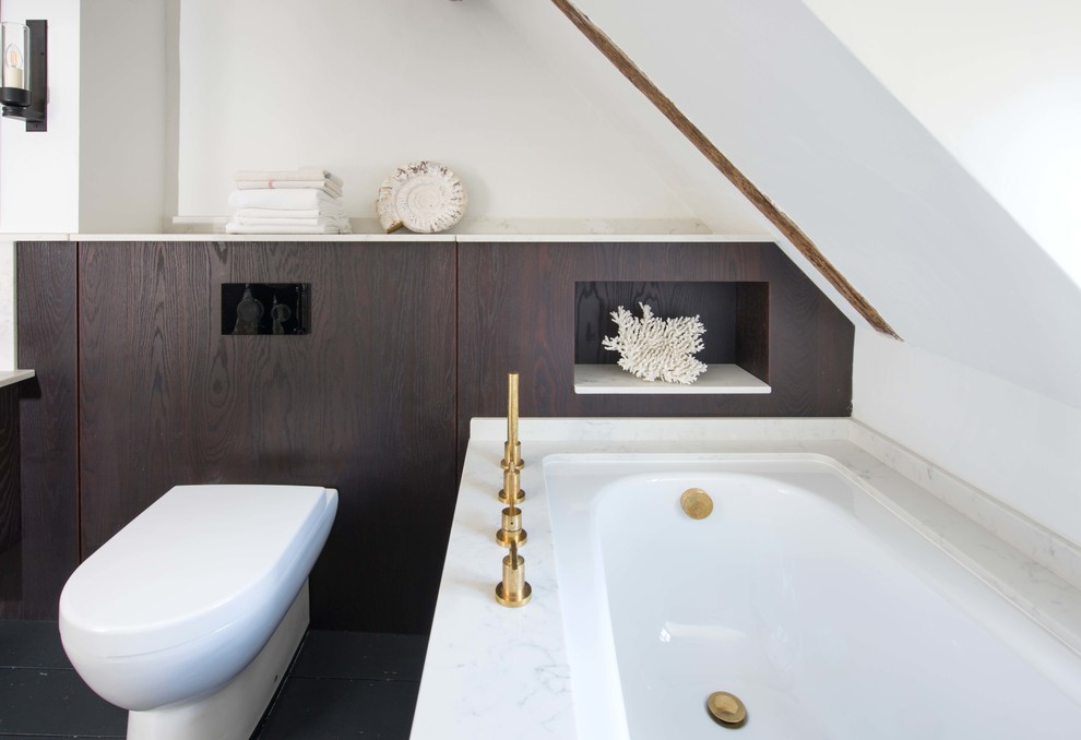 Inspiration pour une petite salle de bain design avec un placard à porte plane, des portes de placard marrons, une baignoire d'angle, WC suspendus, un mur blanc, un sol noir et un plan de toilette blanc.