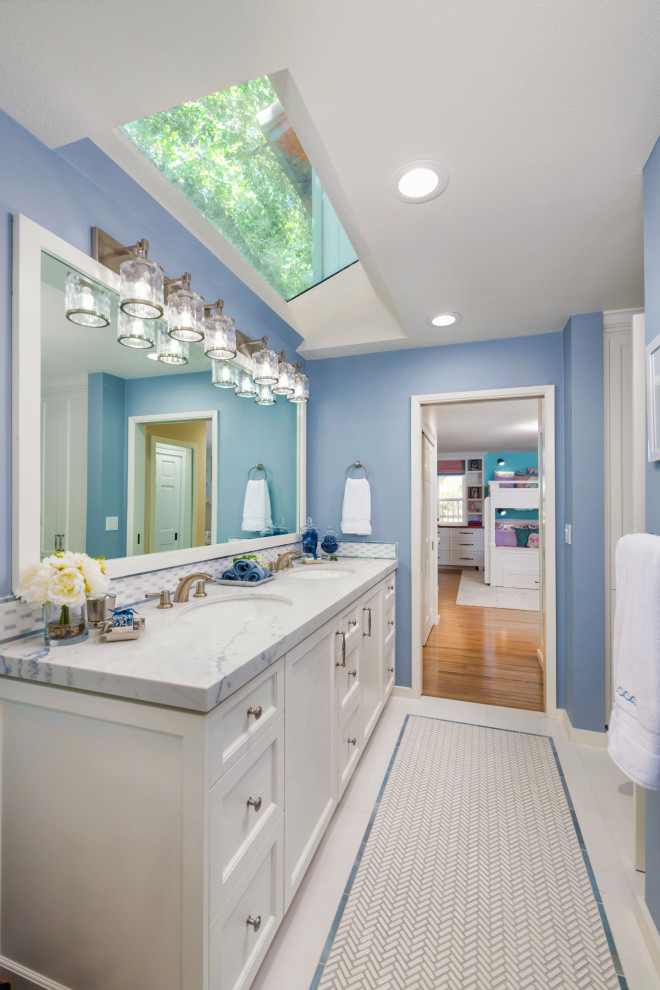 This is an example of a traditional bathroom in San Francisco with recessed-panel cabinets, white cabinets, blue walls, mosaic tile flooring, a submerged sink, white floors, white worktops, double sinks and a built in vanity unit.