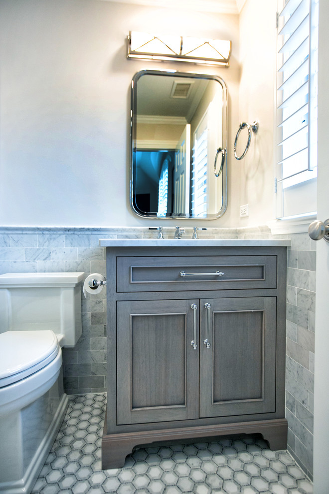 На фото: ванная комната среднего размера в классическом стиле с фасадами островного типа, серыми фасадами, душем в нише, унитазом-моноблоком, белой плиткой, мраморной плиткой, серыми стенами, мраморным полом, врезной раковиной, мраморной столешницей, белым полом, душем с распашными дверями и белой столешницей