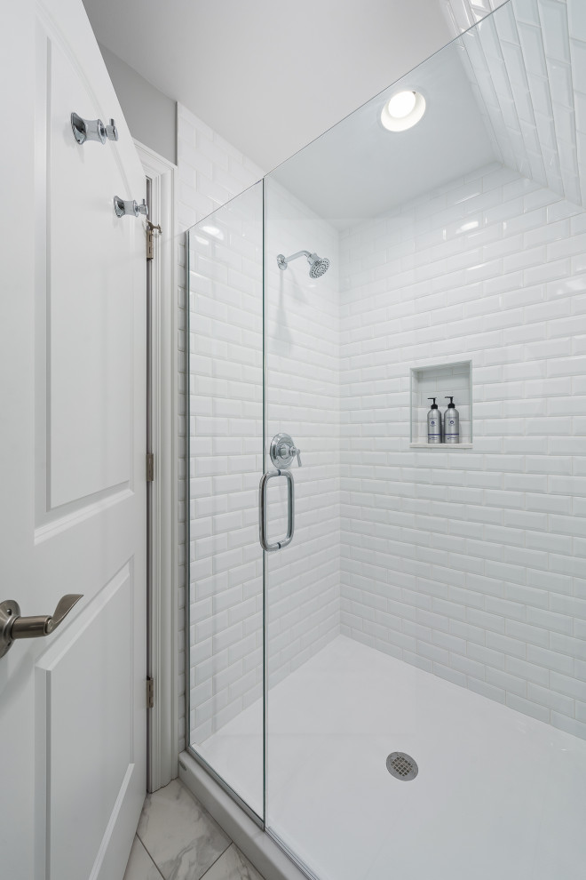 Пример оригинального дизайна: большая детская ванная комната в стиле неоклассика (современная классика) с плоскими фасадами, белыми фасадами, душем в нише, унитазом-моноблоком, белой плиткой, керамогранитной плиткой, серыми стенами, полом из керамогранита, врезной раковиной, столешницей из искусственного кварца, серым полом, душем с распашными дверями, белой столешницей, тумбой под одну раковину и встроенной тумбой