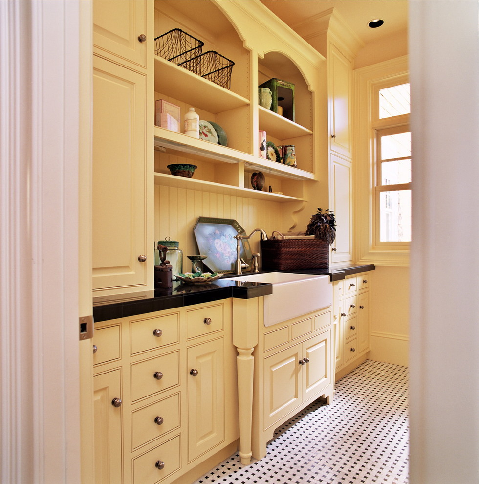 На фото: ванная комната в классическом стиле с накладной раковиной, желтыми фасадами, желтыми стенами, фасадами с выступающей филенкой и разноцветным полом с