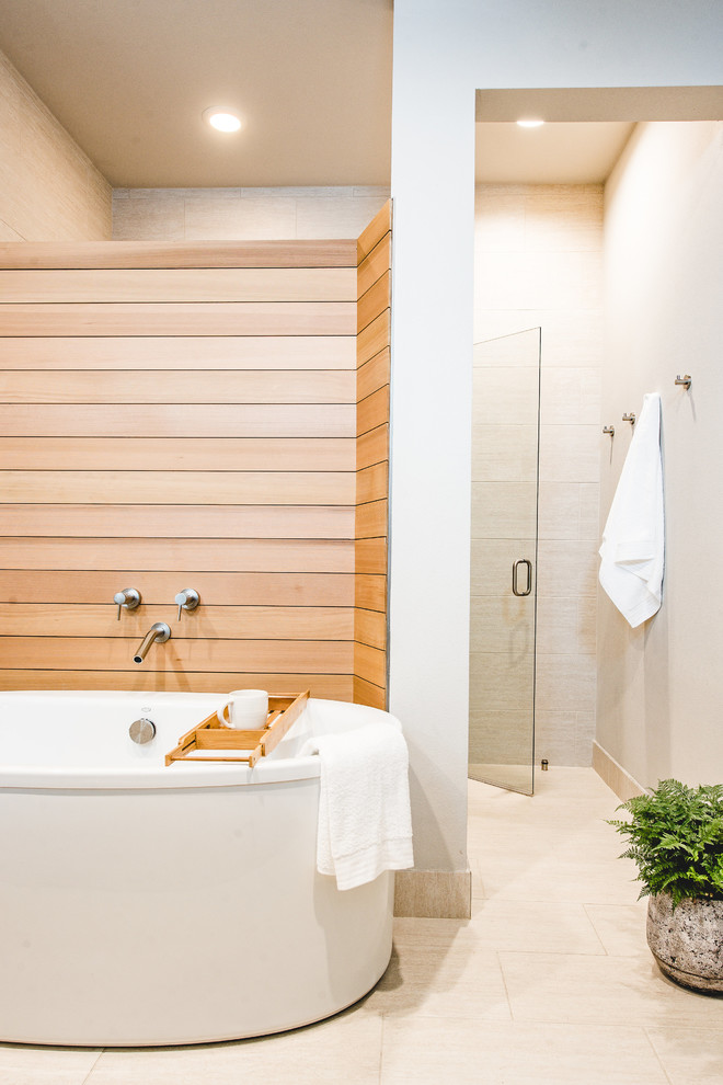 Bild på ett mellanstort funkis en-suite badrum, med ett fristående badkar, en dusch i en alkov, beige kakel, beige väggar, travertin golv och dusch med gångjärnsdörr