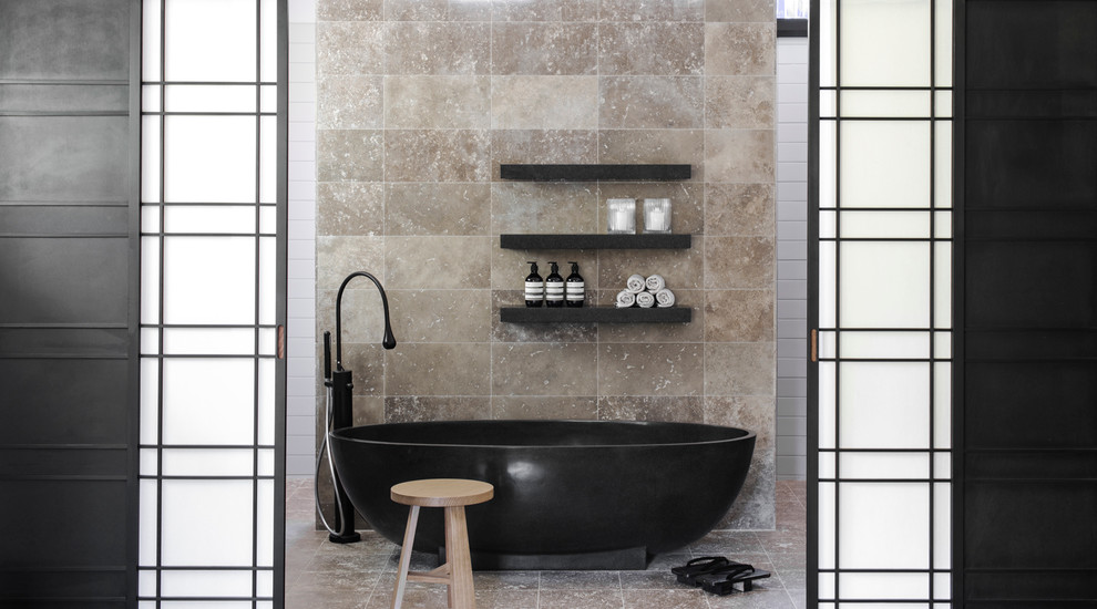 This is an example of a contemporary bathroom in Sydney with a freestanding bath, beige tiles, beige floors and travertine tiles.