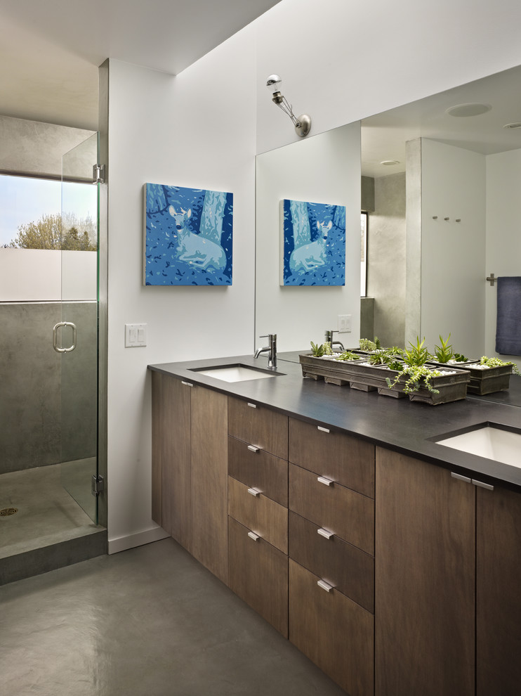 Design ideas for a small modern ensuite bathroom in Seattle with a submerged sink, flat-panel cabinets, medium wood cabinets, solid surface worktops, a double shower, a two-piece toilet, white walls and concrete flooring.