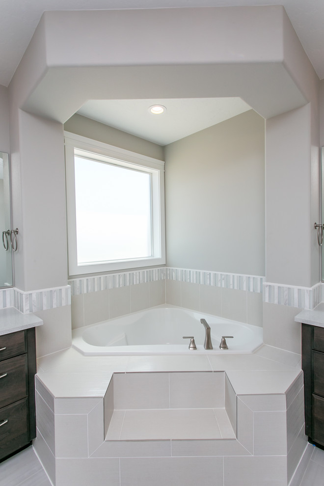 Bild på ett stort vintage vit vitt en-suite badrum, med luckor med infälld panel, skåp i mörkt trä, ett hörnbadkar, en kantlös dusch, en toalettstol med separat cisternkåpa, grön kakel, glaskakel, grå väggar, klinkergolv i porslin, ett undermonterad handfat, bänkskiva i kvarts, grått golv och med dusch som är öppen