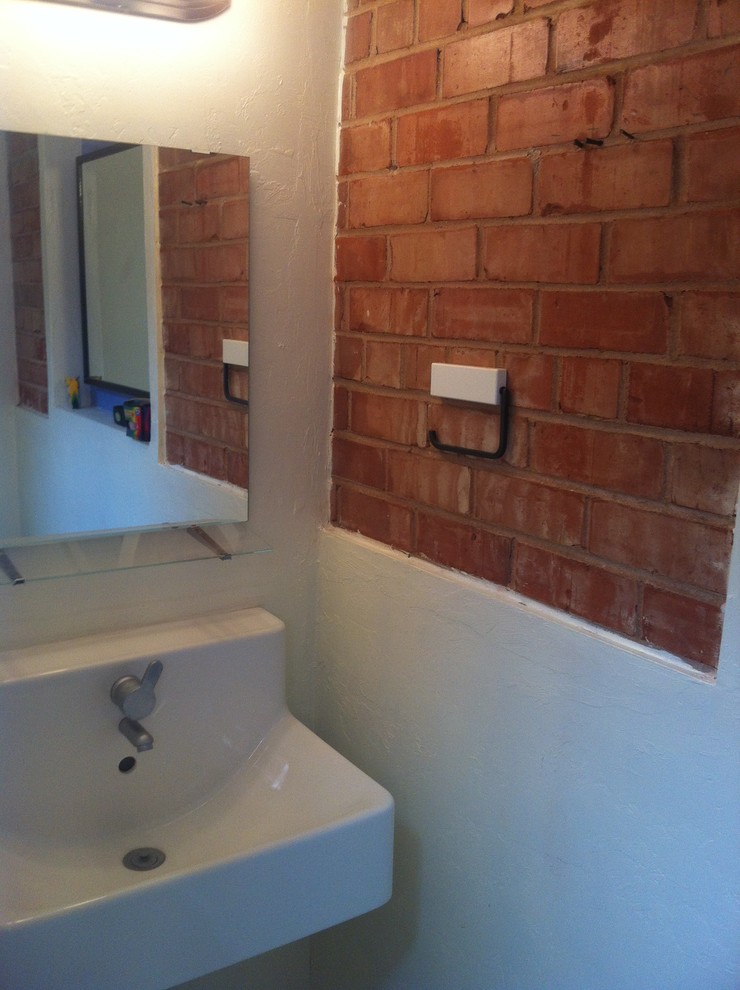 Aménagement d'une petite salle de bain contemporaine avec un mur jaune et un lavabo suspendu.