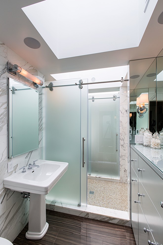 Inspiration for a contemporary bathroom in New York with a pedestal sink, flat-panel cabinets and white cabinets.