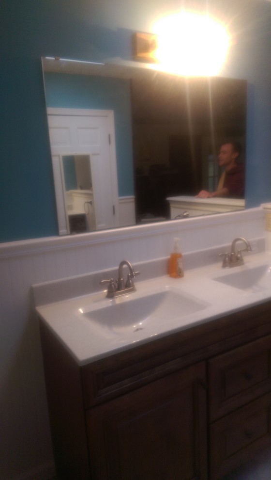 Inredning av ett klassiskt mellanstort en-suite badrum, med ett integrerad handfat, luckor med upphöjd panel, skåp i mellenmörkt trä, bänkskiva i akrylsten, en dusch i en alkov, en toalettstol med separat cisternkåpa, blå väggar och klinkergolv i porslin