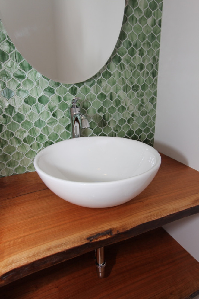Cette photo montre une petite salle de bain montagne en bois brun avec WC à poser, un carrelage vert, un carrelage en pâte de verre, un mur vert, un sol en bois brun, une vasque, un plan de toilette en bois, un sol marron, un plan de toilette marron, meuble simple vasque et meuble-lavabo suspendu.