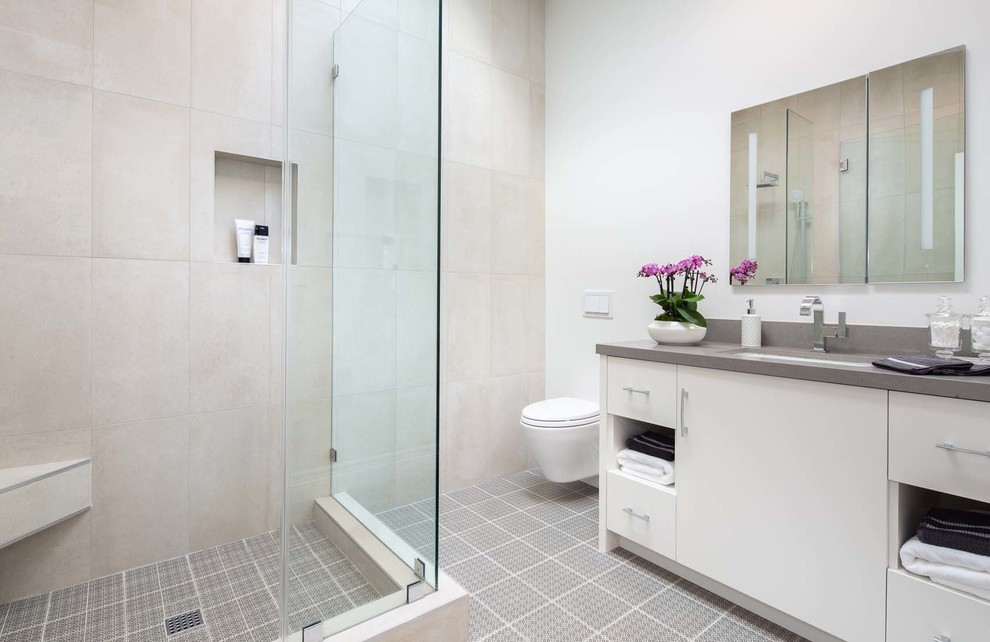 Inspiration för mellanstora moderna grått en-suite badrum, med släta luckor, vita skåp, en dusch i en alkov, en vägghängd toalettstol, grå kakel, keramikplattor, vita väggar, klinkergolv i keramik, ett undermonterad handfat, bänkskiva i kvarts, grått golv och dusch med gångjärnsdörr