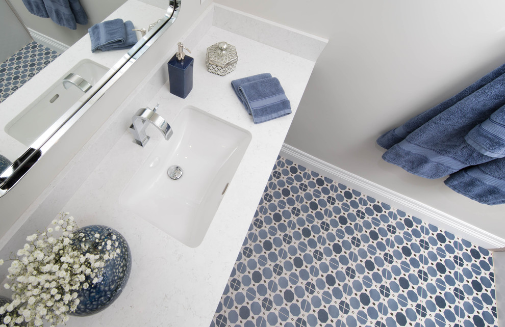 Свежая идея для дизайна: ванная комната среднего размера в современном стиле с плоскими фасадами, серыми фасадами, ванной в нише, душем над ванной, унитазом-моноблоком, серой плиткой, керамической плиткой, серыми стенами, полом из керамической плитки, врезной раковиной, столешницей из искусственного кварца, синим полом, душем с раздвижными дверями и белой столешницей - отличное фото интерьера