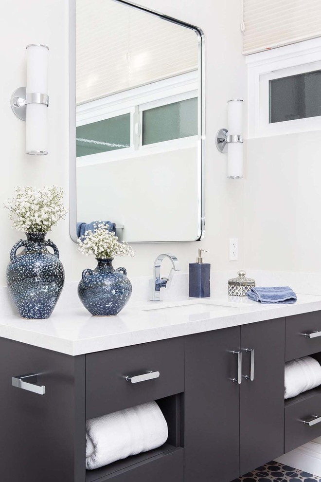 Стильный дизайн: ванная комната среднего размера в современном стиле с плоскими фасадами, серыми фасадами, ванной в нише, душем над ванной, унитазом-моноблоком, серой плиткой, керамической плиткой, серыми стенами, полом из керамической плитки, врезной раковиной, столешницей из искусственного кварца, синим полом, душем с раздвижными дверями и белой столешницей - последний тренд