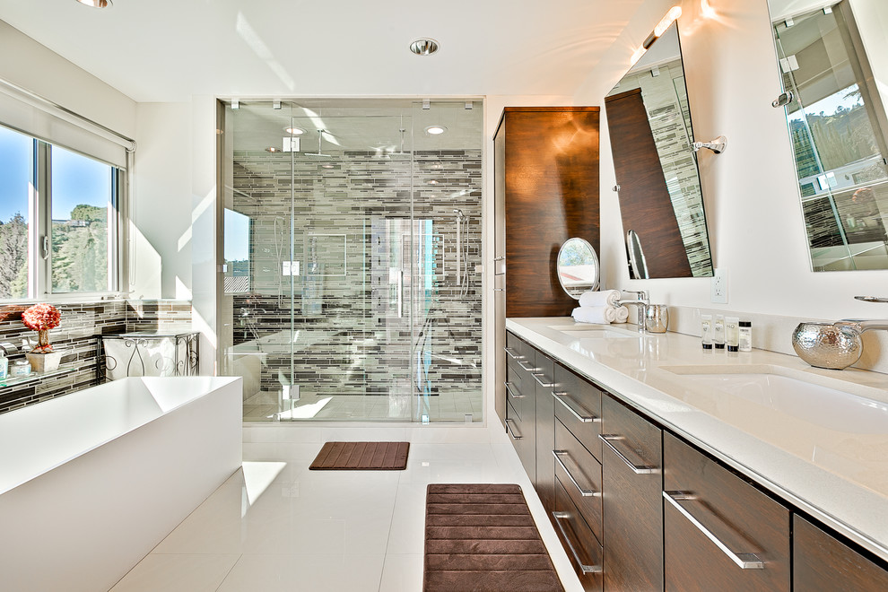 Стильный дизайн: главная ванная комната среднего размера в современном стиле с плоскими фасадами, темными деревянными фасадами, отдельно стоящей ванной, душем в нише, коричневой плиткой, разноцветной плиткой, белой плиткой, удлиненной плиткой, белыми стенами, полом из керамической плитки, врезной раковиной, столешницей из гранита, душем с распашными дверями, белым полом и бежевой столешницей - последний тренд