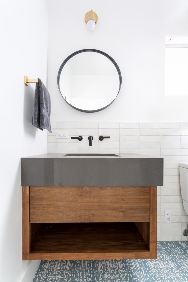 This is an example of a medium sized midcentury bathroom in Los Angeles with flat-panel cabinets, dark wood cabinets, an alcove shower, a one-piece toilet, white tiles, ceramic tiles, white walls, cement flooring, a submerged sink, engineered stone worktops, blue floors, a hinged door and white worktops.