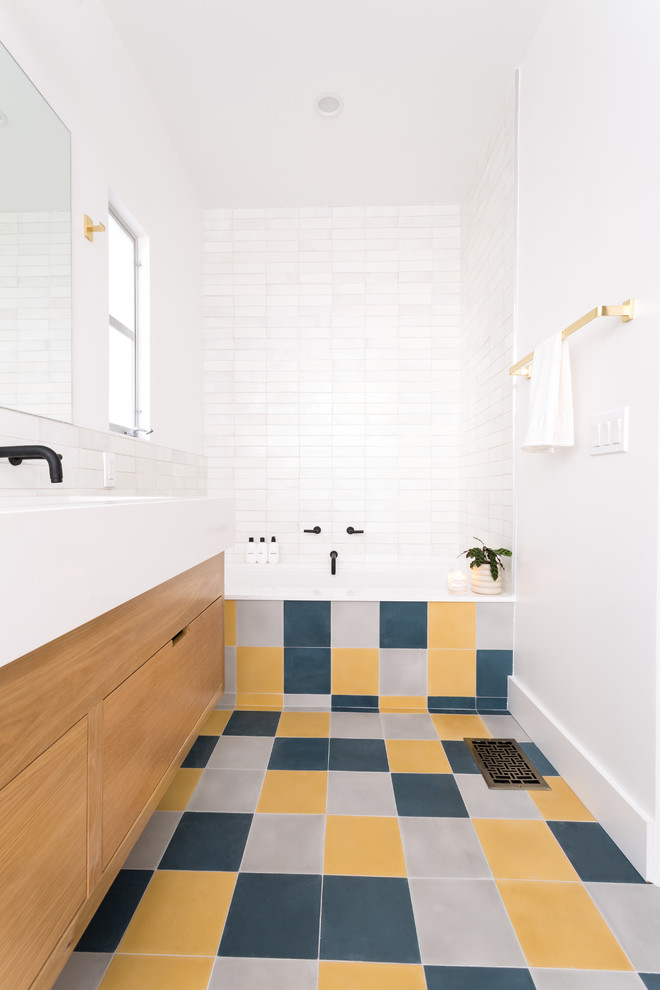 Medium sized retro bathroom in Los Angeles with flat-panel cabinets, light wood cabinets, a built-in bath, an alcove shower, a one-piece toilet, white tiles, ceramic tiles, white walls, cement flooring, a submerged sink, engineered stone worktops, a hinged door and white worktops.