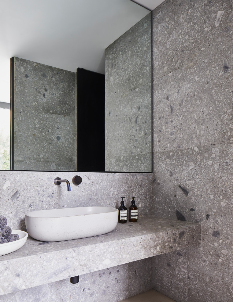 Contemporary bathroom in London with grey tiles, a vessel sink, grey worktops and a single sink.