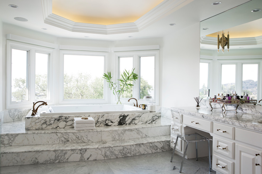 На фото: большая главная ванная комната в морском стиле с белыми фасадами, белой плиткой, мраморной плиткой, белыми стенами, мраморным полом, мраморной столешницей, белым полом и белой столешницей
