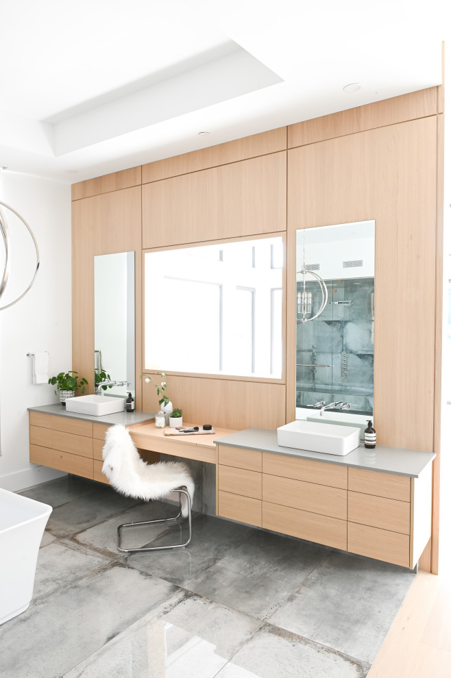 Идея дизайна: главная ванная комната в современном стиле с светлыми деревянными фасадами, отдельно стоящей ванной, белыми стенами, настольной раковиной, столешницей из кварцита, душем с распашными дверями и серой столешницей