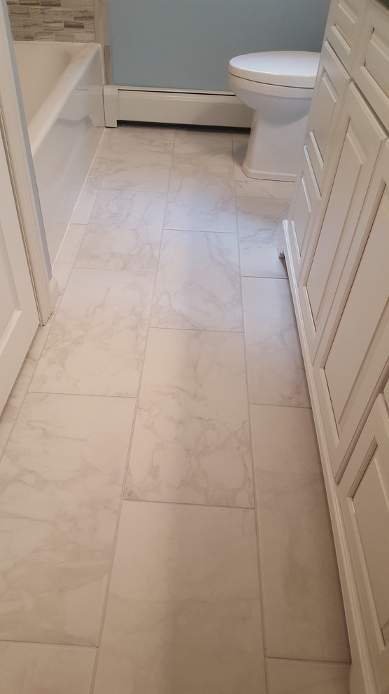 Inspiration for a small transitional 3/4 gray tile, white tile and matchstick tile marble floor bathroom remodel in Boston with shaker cabinets, white cabinets, a two-piece toilet, blue walls, an undermount sink and quartz countertops