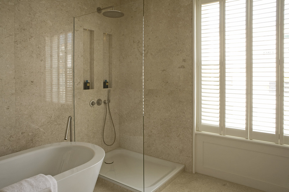 Cette photo montre une salle de bain principale tendance de taille moyenne avec un lavabo intégré, un plan de toilette en marbre, une baignoire indépendante, une douche ouverte, WC à poser, un carrelage beige, des dalles de pierre, un mur beige et un sol en marbre.
