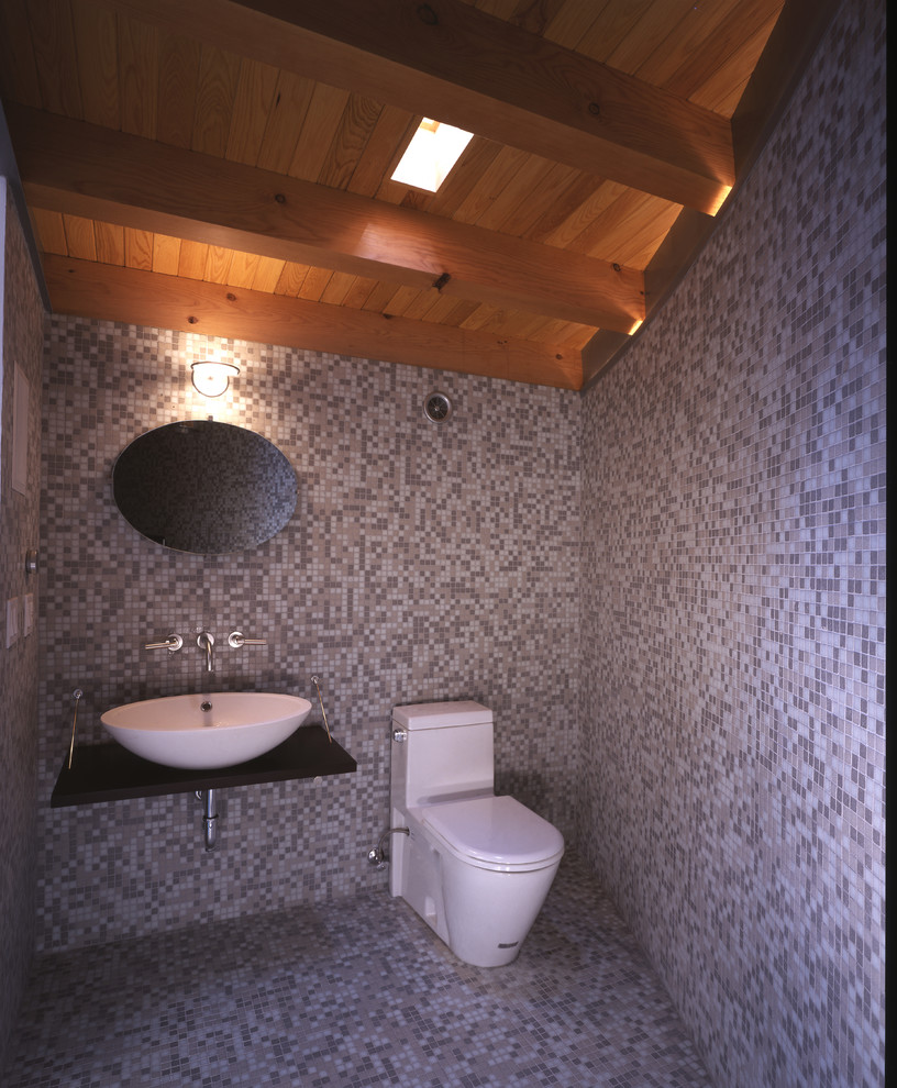 Example of a mid-sized minimalist master mosaic tile and beige tile light wood floor and beige floor bathroom design in San Francisco with a one-piece toilet, a vessel sink, wood countertops, a hot tub and beige walls