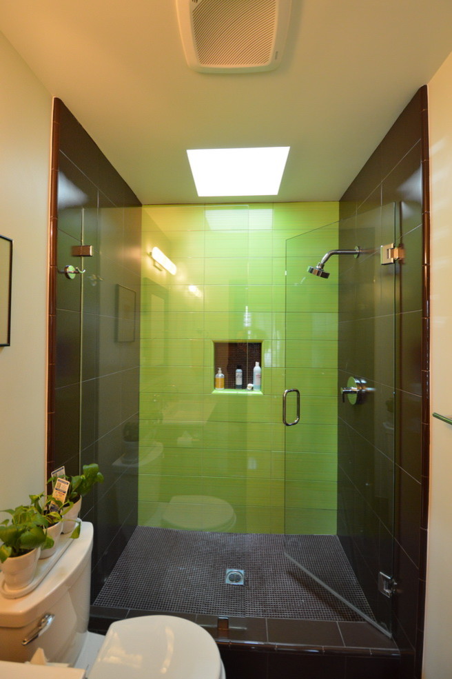 ロサンゼルスにあるミッドセンチュリースタイルのおしゃれなバスルーム (浴槽なし) (オーバーカウンターシンク、フラットパネル扉のキャビネット、中間色木目調キャビネット、アルコーブ型シャワー、分離型トイレ、黒いタイル、セラミックタイル、白い壁、セラミックタイルの床) の写真