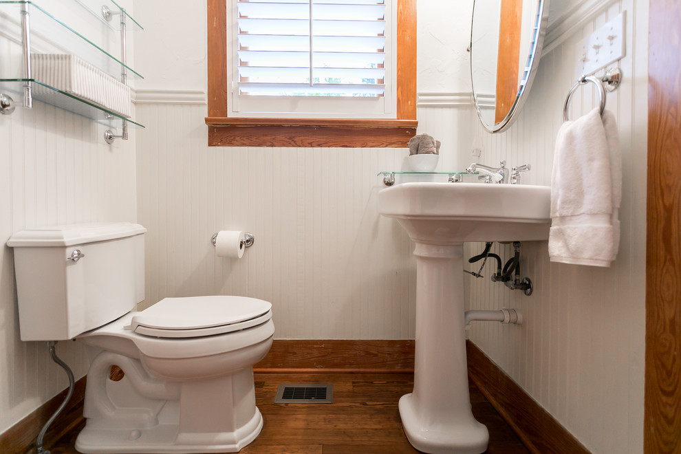 Ejemplo de cuarto de baño campestre pequeño con sanitario de una pieza, paredes blancas, suelo de madera clara, aseo y ducha y lavabo con pedestal