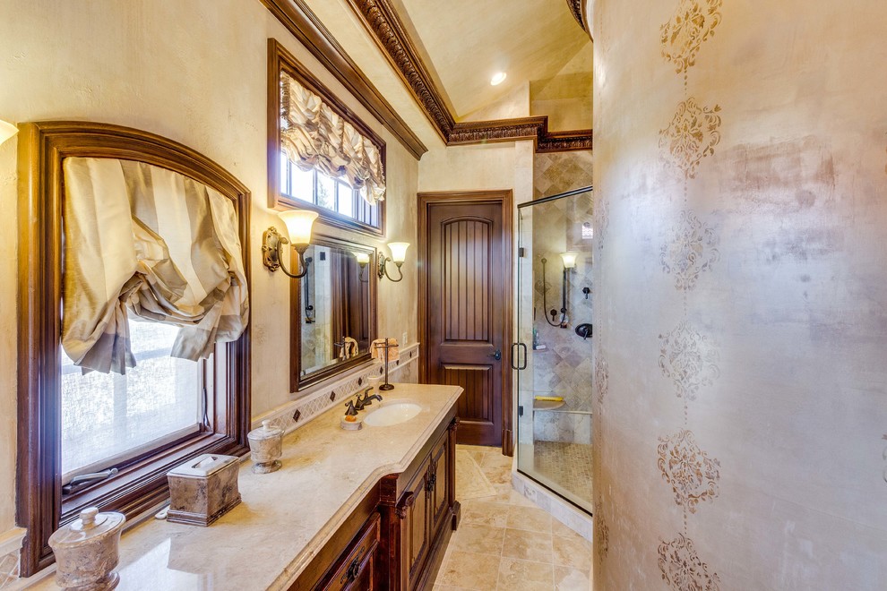 Пример оригинального дизайна: главная ванная комната среднего размера в классическом стиле с фасадами с утопленной филенкой, темными деревянными фасадами, накладной ванной, угловым душем, бежевой плиткой, плиткой мозаикой, бежевыми стенами, полом из травертина, врезной раковиной, мраморной столешницей, бежевым полом и душем с распашными дверями
