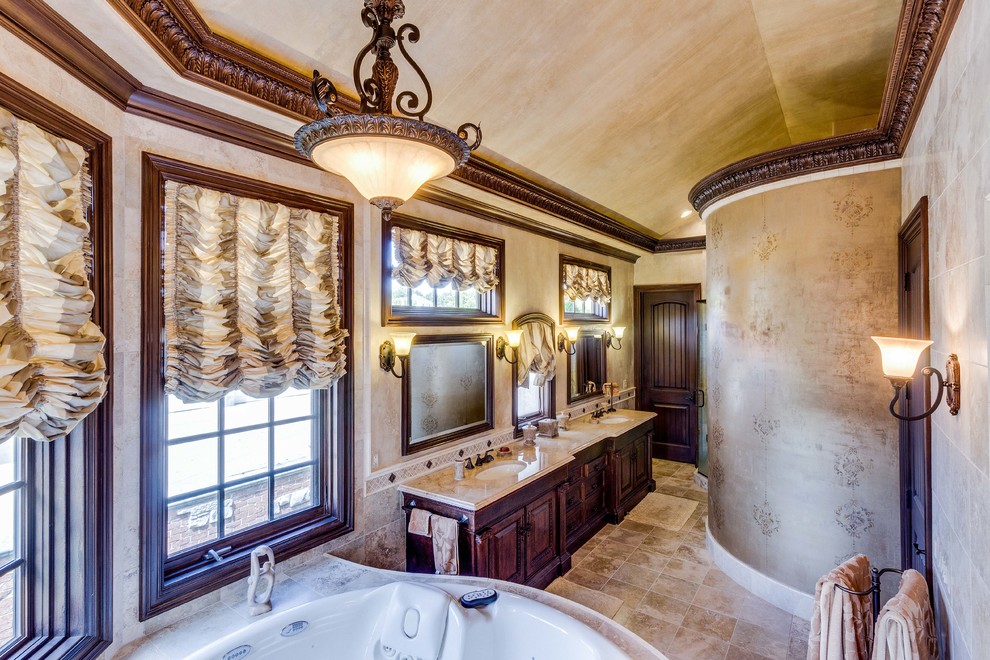 Cette image montre une salle de bain principale traditionnelle en bois foncé de taille moyenne avec un placard avec porte à panneau encastré, une baignoire posée, une douche d'angle, un carrelage beige, mosaïque, un mur beige, un sol en travertin, un lavabo encastré, un plan de toilette en marbre, un sol beige et une cabine de douche à porte battante.