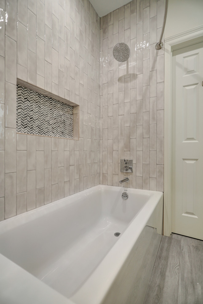 Inspiration for a medium sized traditional family bathroom in Houston with shaker cabinets, white cabinets, an alcove bath, a shower/bath combination, a one-piece toilet, grey tiles, cement tiles, white walls, ceramic flooring, a built-in sink, quartz worktops, grey floors, a shower curtain, white worktops, a wall niche, a single sink and a built in vanity unit.