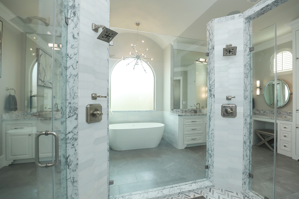 Photo of an expansive traditional ensuite bathroom in Houston with raised-panel cabinets, white cabinets, a freestanding bath, a double shower, a vessel sink, marble worktops and an open shower.