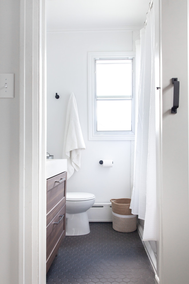 Aménagement d'une petite salle d'eau moderne avec un placard à porte shaker, des portes de placard blanches, une baignoire en alcôve, un combiné douche/baignoire, un mur blanc, un sol en carrelage de porcelaine, un lavabo intégré, un plan de toilette en quartz modifié, un sol noir, une cabine de douche avec un rideau, un plan de toilette blanc et WC séparés.