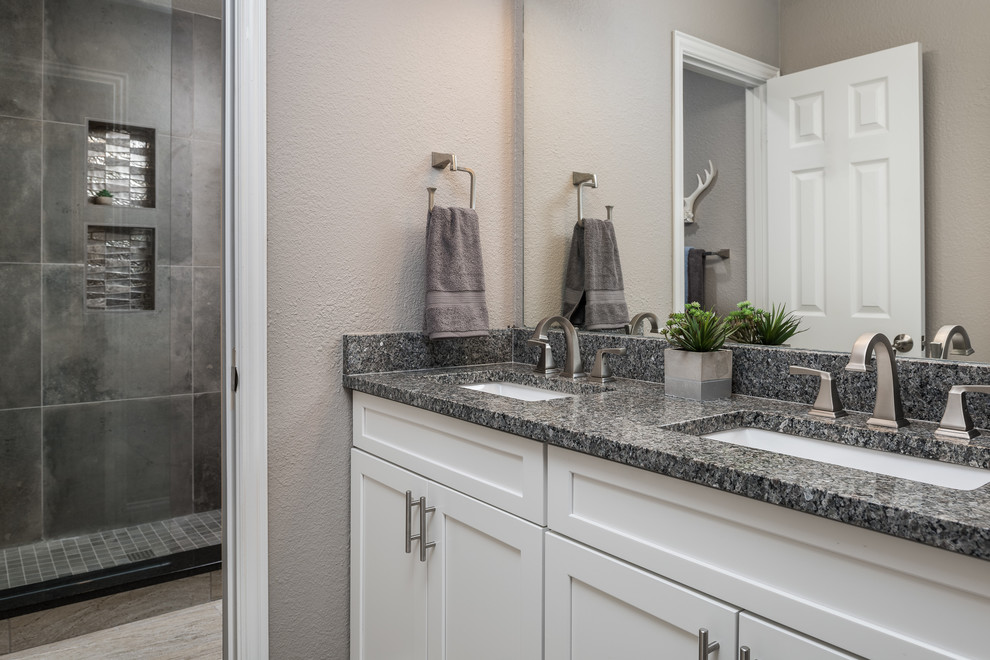 This is an example of a large modern ensuite bathroom in Dallas with recessed-panel cabinets, white cabinets, an alcove shower, a one-piece toilet, multi-coloured tiles, mosaic tiles, grey walls, light hardwood flooring, a submerged sink, marble worktops, grey floors and an open shower.
