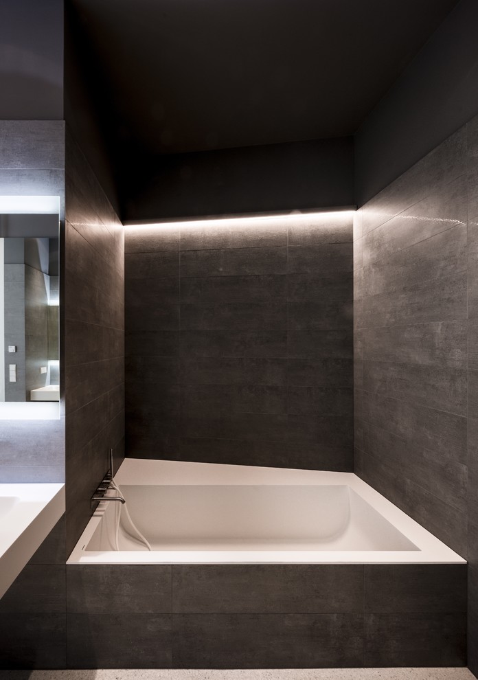 Idee per una stanza da bagno minimalista di medie dimensioni con piastrelle grigie, piastrelle nere, piastrelle in gres porcellanato, pareti grigie, pavimento in cemento, vasca ad alcova e pavimento grigio