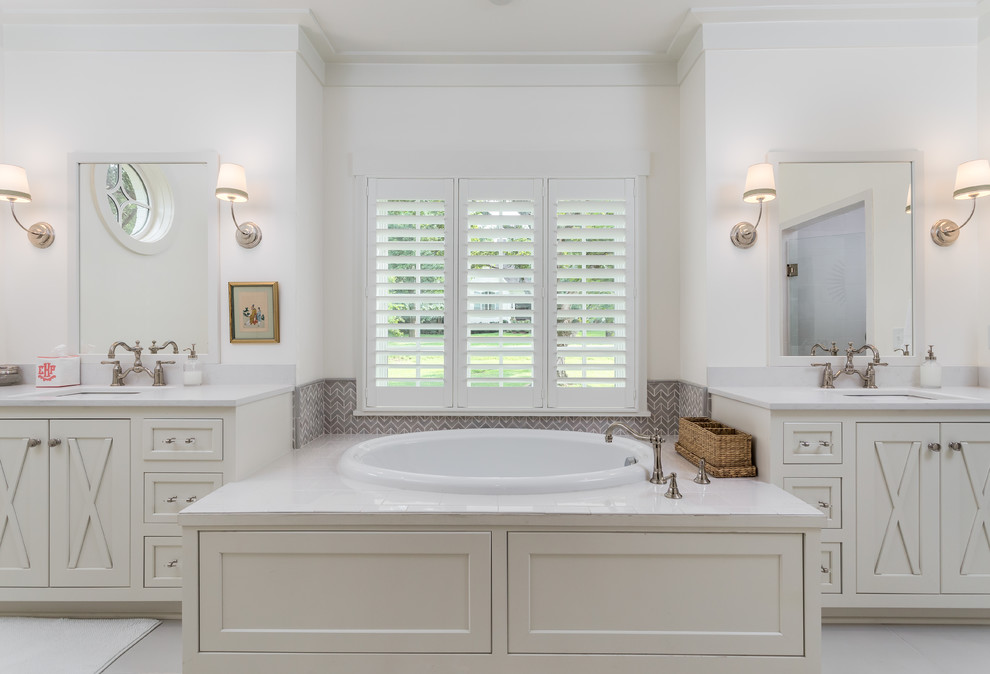 Modelo de cuarto de baño principal campestre grande con puertas de armario blancas, bañera encastrada, baldosas y/o azulejos marrones, paredes blancas y encimera de cuarcita