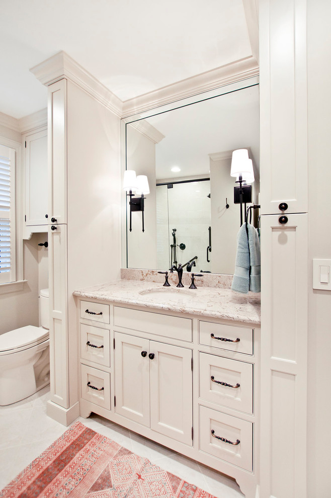 Mid-sized elegant master white tile and porcelain tile porcelain tile and white floor alcove shower photo in Nashville with recessed-panel cabinets, white cabinets, a two-piece toilet, white walls, an undermount sink, quartz countertops, a hinged shower door and multicolored countertops