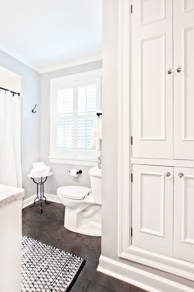 Inredning av ett klassiskt litet flerfärgad flerfärgat badrum för barn, med luckor med infälld panel, vita skåp, en dusch i en alkov, en toalettstol med separat cisternkåpa, vit kakel, porslinskakel, grå väggar, klinkergolv i porslin, ett undermonterad handfat, brunt golv, dusch med duschdraperi, granitbänkskiva och ett badkar i en alkov