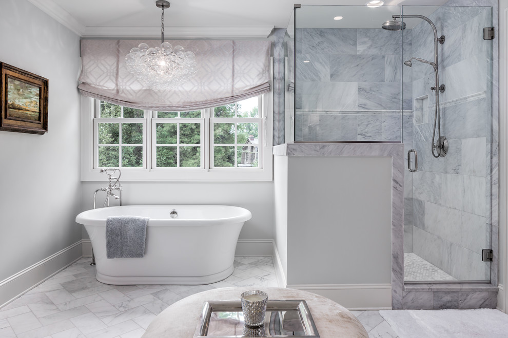 Photo of a large classic ensuite bathroom in Nashville with a freestanding bath, a corner shower, grey tiles, marble tiles, grey walls, marble flooring, grey floors and a hinged door.