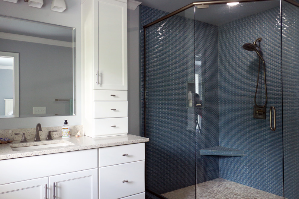 Cette image montre une salle de bain principale marine de taille moyenne avec un placard avec porte à panneau encastré, des portes de placard blanches, une baignoire en alcôve, une douche d'angle, WC à poser, un carrelage bleu, mosaïque, un mur gris, un sol en carrelage de terre cuite, un lavabo encastré, un plan de toilette en quartz modifié, un sol beige et une cabine de douche à porte battante.