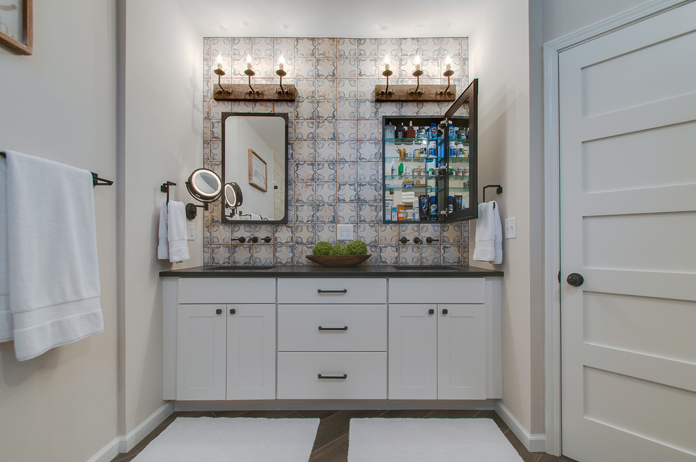 Example of a mid-sized tuscan master white tile and ceramic tile ceramic tile and brown floor walk-in shower design in Nashville with shaker cabinets, white cabinets, a one-piece toilet, white walls, an undermount sink, granite countertops, a hinged shower door and gray countertops