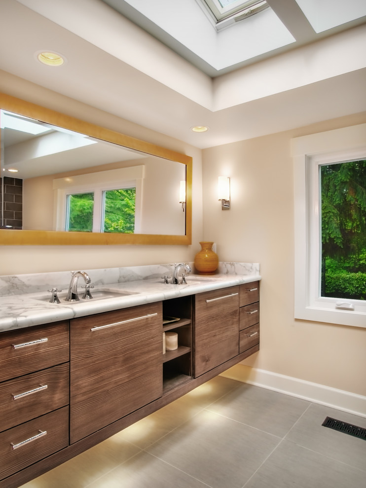 Foto di una stanza da bagno padronale contemporanea di medie dimensioni con ante in legno bruno, ante lisce, top in marmo, piastrelle grigie, pareti beige e lavabo sottopiano