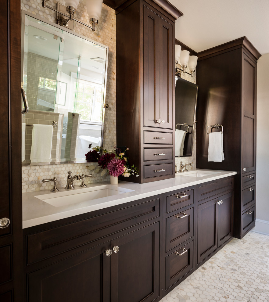 Photo of a large classic ensuite bathroom in Seattle with beaded cabinets, dark wood cabinets, a freestanding bath, a corner shower, a two-piece toilet, grey tiles, ceramic tiles, white walls, marble flooring, a submerged sink, engineered stone worktops, white floors and a hinged door.
