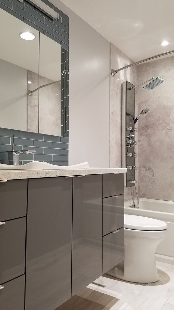 Bathroom - mid-sized contemporary kids' gray tile and stone slab porcelain tile and gray floor bathroom idea in Other with flat-panel cabinets, gray cabinets, a one-piece toilet, gray walls, a vessel sink and quartz countertops