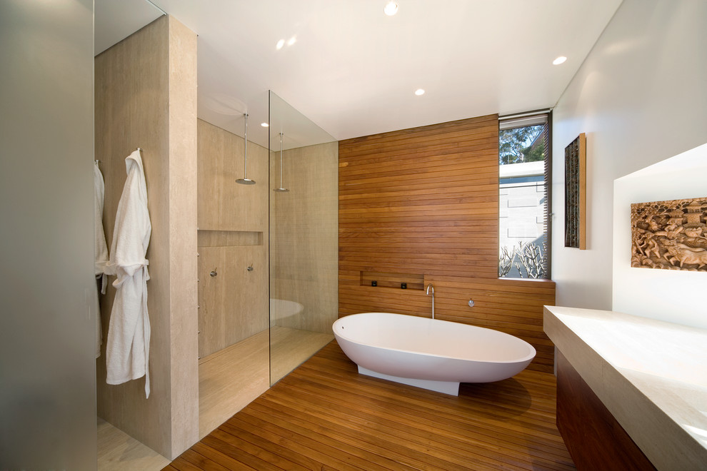 シドニーにあるモダンスタイルのおしゃれなマスターバスルーム (フラットパネル扉のキャビネット、中間色木目調キャビネット、置き型浴槽、ベージュのタイル、無垢フローリング、オープンシャワー、ダブルシャワー) の写真
