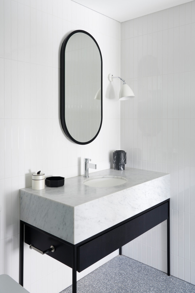 Immagine di una stanza da bagno contemporanea con consolle stile comò, ante nere e top in marmo