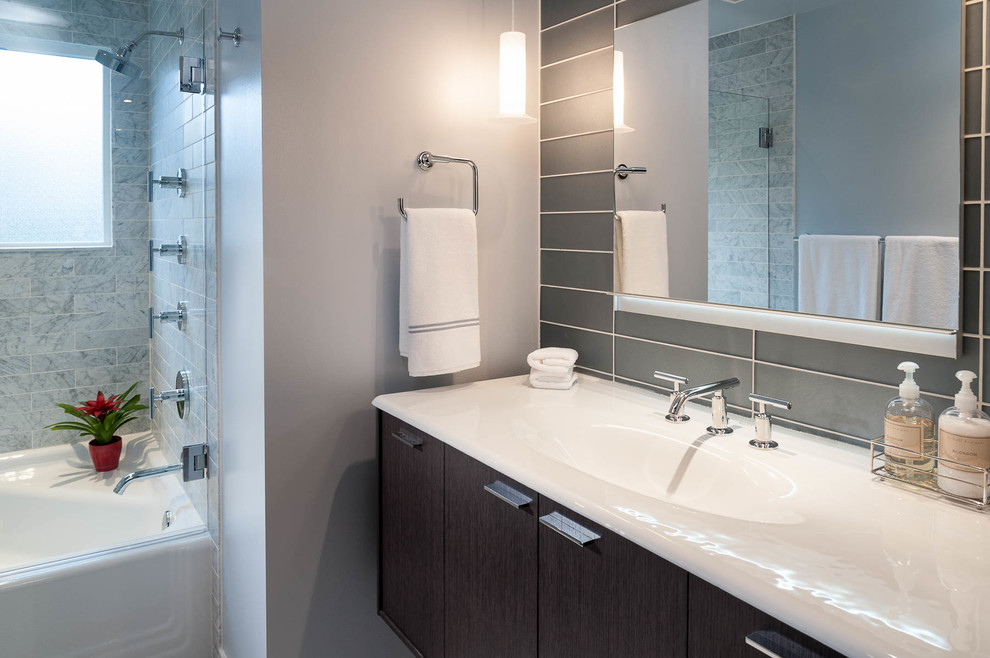 Exemple d'une salle de bain moderne de taille moyenne avec un lavabo posé, des portes de placard marrons, une baignoire en alcôve, une douche d'angle, un carrelage gris, un carrelage en pâte de verre, un mur gris et un sol en marbre.