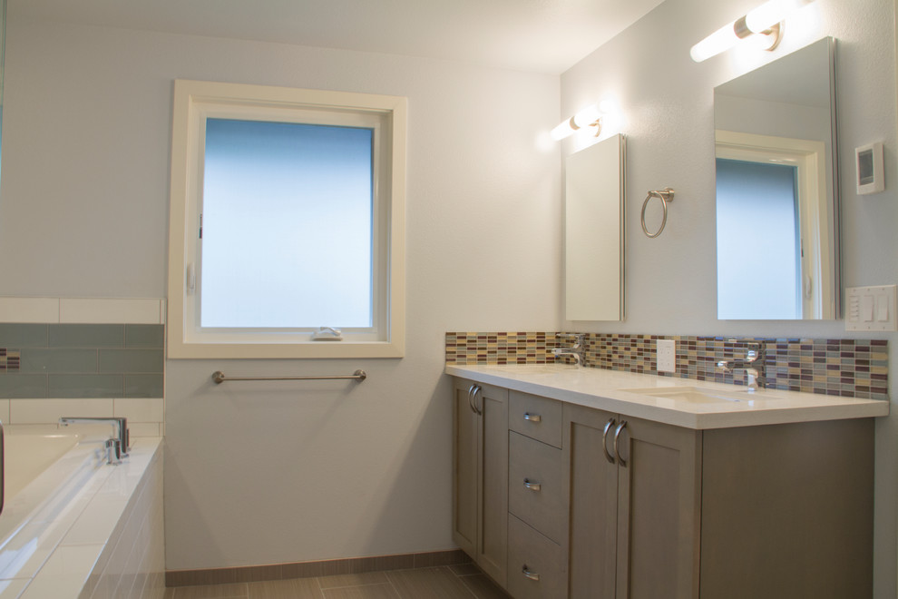 Свежая идея для дизайна: большая главная ванная комната в стиле ретро с врезной раковиной, фасадами в стиле шейкер, серыми фасадами, столешницей из искусственного камня, накладной ванной, двойным душем, унитазом-моноблоком, синей плиткой, стеклянной плиткой, белыми стенами и полом из керамической плитки - отличное фото интерьера