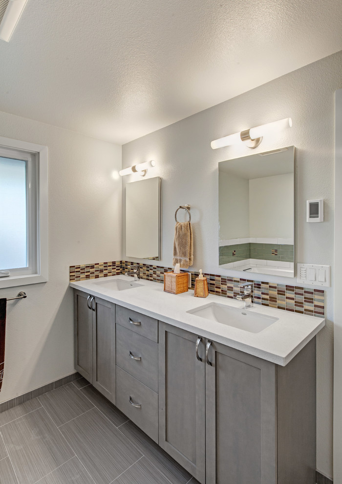 Inspiration for a large 1960s master glass tile and multicolored tile ceramic tile bathroom remodel in Seattle with an undermount sink, shaker cabinets, medium tone wood cabinets, quartz countertops, a one-piece toilet and white walls