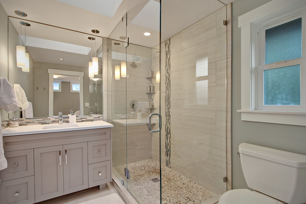 Mid-sized arts and crafts master beige tile and porcelain tile porcelain tile corner shower photo in Seattle with an undermount sink, recessed-panel cabinets, gray cabinets, quartz countertops, a two-piece toilet and gray walls