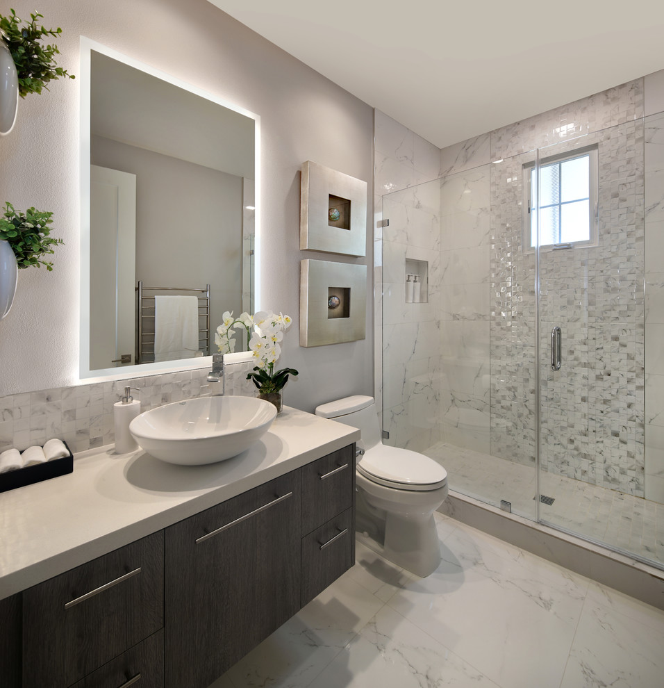 Alcove shower - small modern 3/4 white tile and porcelain tile porcelain tile and white floor alcove shower idea in Orange County with flat-panel cabinets, dark wood cabinets, a one-piece toilet, gray walls, a vessel sink, quartz countertops, a hinged shower door and white countertops